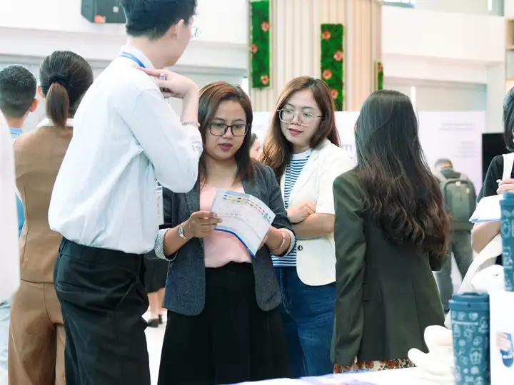 Attendees collecting and opening the programme at the welcome desk