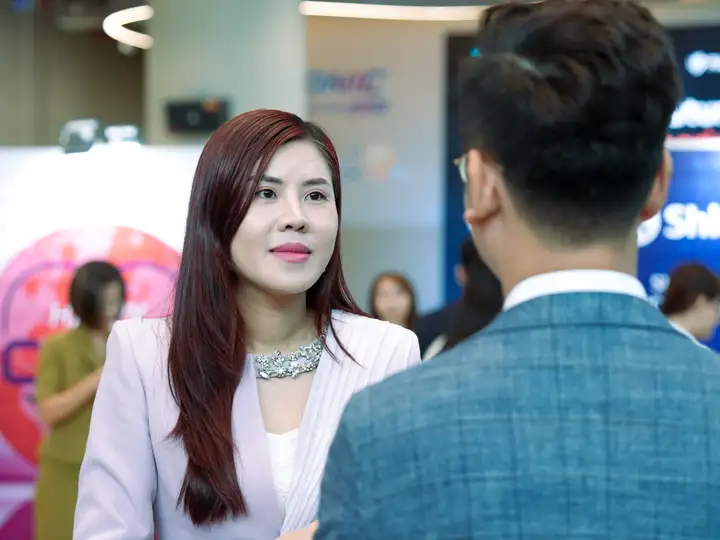Two people talking business beside a sponsor booth
